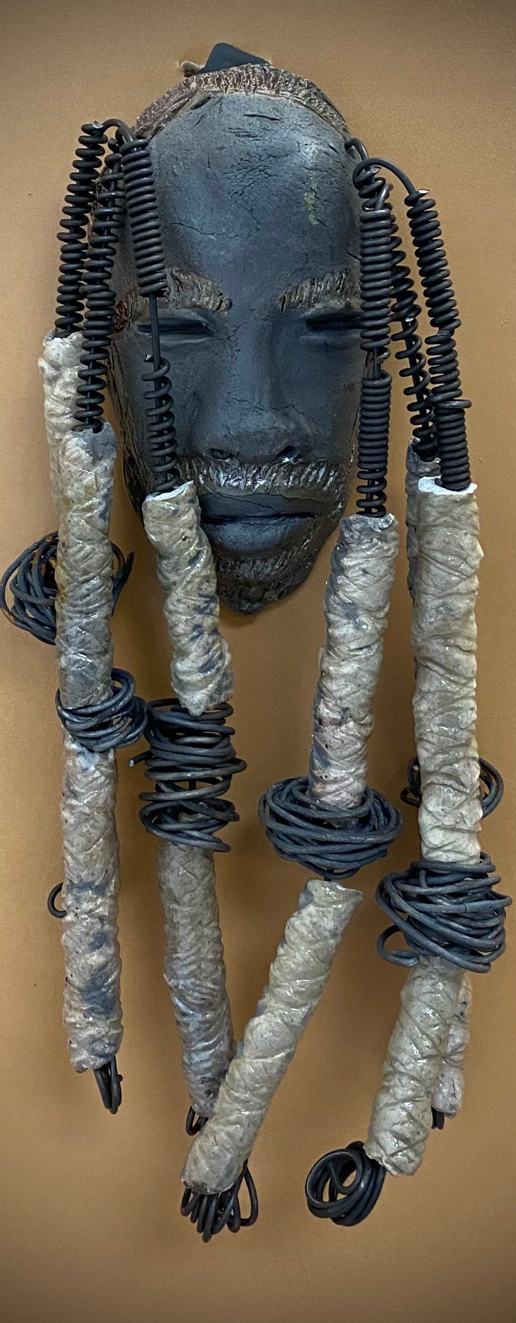 Meet Jude! I started making art soon after seeing authentic African artwork at the Smithsonian Museum of African Art. I was in total awe. Jude was inspired by my visit there. Jude is a wise and distinguished bearded gentleman who has a smoky dark complexion. He is approximately 5" x 10" and weighs 14 ozs. Jude has an aged hairstyle of 12 large handmade textured off white clay dreadlocks along with twist of coiled 16 gauge wire.