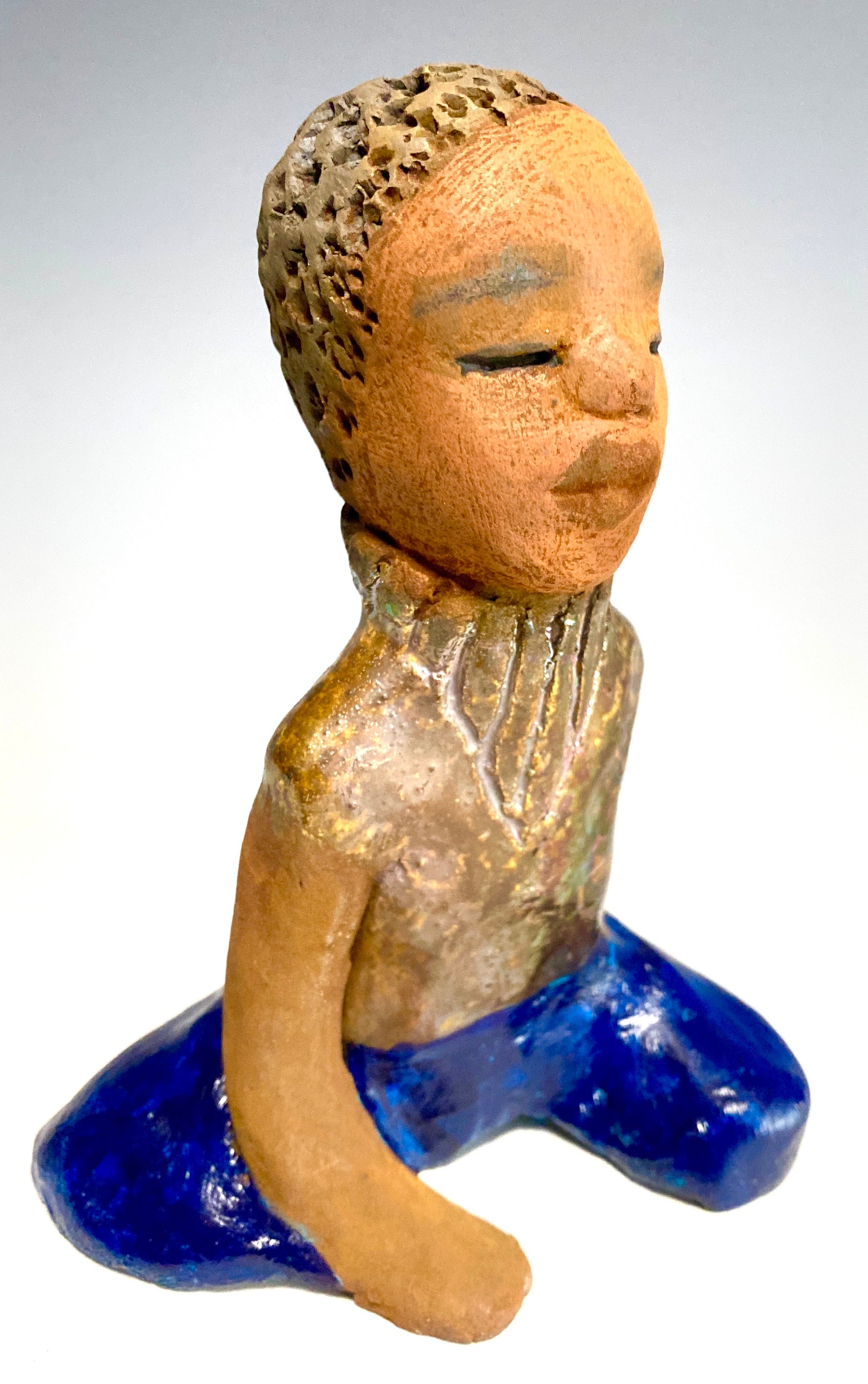 Anthony is one confident preteen who is ready to get back to school!     Anthony stands 5" x 4" x 4" and weighs 12 ozs. He has a metallic green and gold shirt with blue jeans . Anthony complexion is honey brown. He has a  youg gentle spirit One arms is  behind his back as he ponders who will be his favorite teacher.