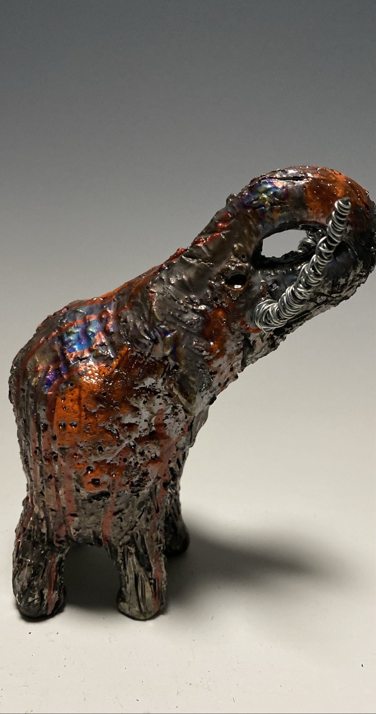 Raku Elephant Have you HERD!!!!!! Just one of these lovely Raku Fired Elephant will make an excellent gift for your friend, sorority or for your home’ special place centerpiece. 6" x 3" x 4" 11 ozs. Beautiful metallic orange raku elephant For decorative purposely only