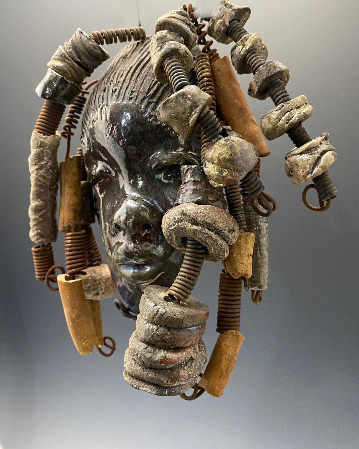 Meet JoAnne I started making art soon after seeing authentic African artwork at the Smithsonian Museum of African Art. I was in total awe. JoAnne was inspired by my visit there. JoAnne has a two tone complexion of black and dark metallic copper. She is 8" x 6" and weighs 14 ozs. Adisa has over 15 handmade raku fired beads. She has over 10 feet of coiled 16 gauge wire hair.