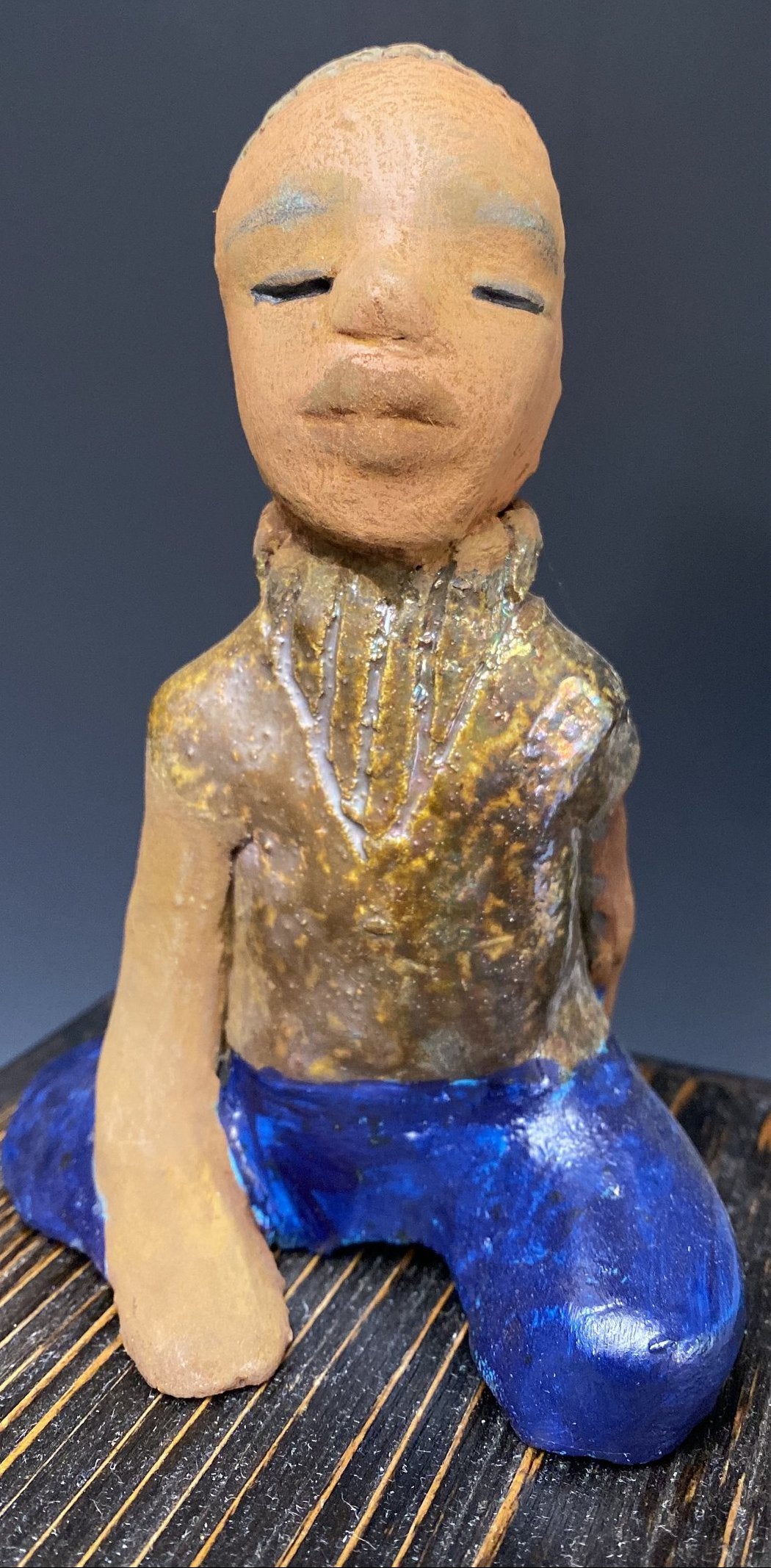 Anthony is one confident preteen who is ready to get back to school!    Anthony stands 5" x 4" x 4" and weighs 12 ozs. He has a metallic green and gold shirt with blue jeans . Anthony complexion is honey brown. He has a  young gentle spirit One arms is  behind his back as he ponders who will be his favorite teacher.