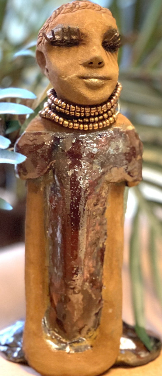 Meet Morgan! Morgan stands 9' x 4"x 3.5" and weighs 1 lbs. She has bright honey brown complexion. Her dress is a s Morgan wears an amber beaded necklace Her long trademark arms rest at her side. Morgan is waiting for a new home!