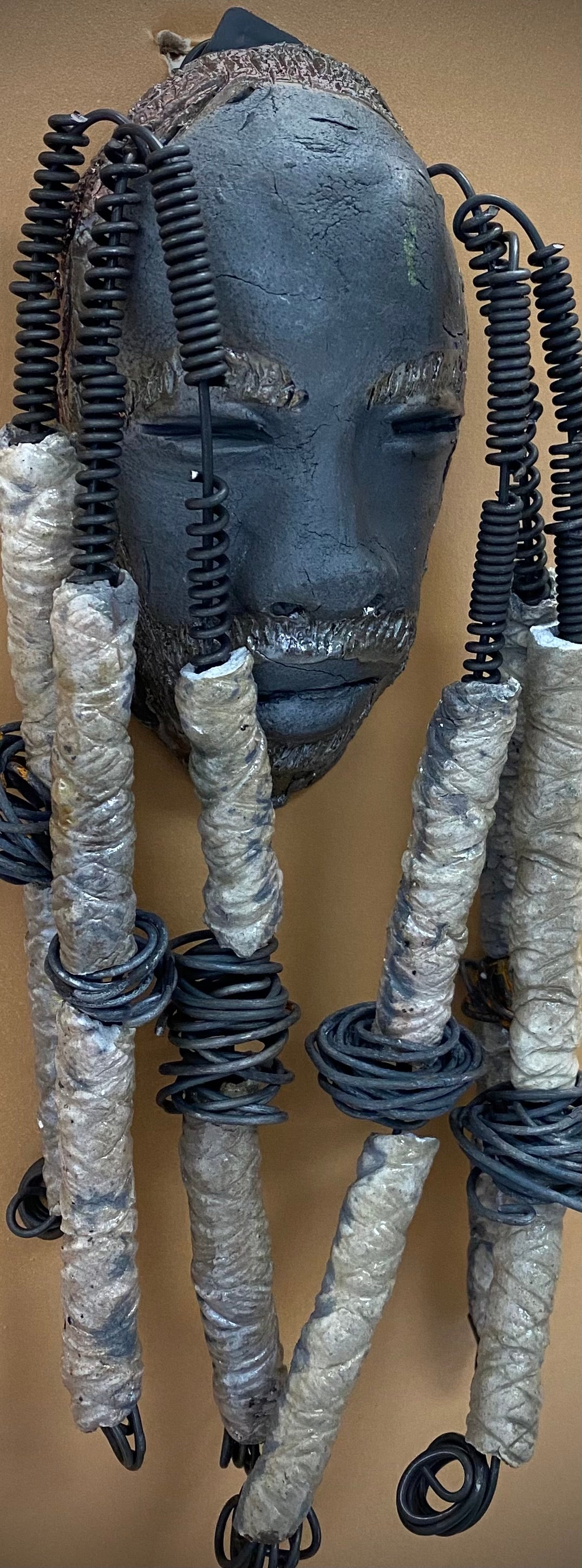 Meet Jude! I started making art soon after seeing authentic African artwork at the Smithsonian Museum of African Art. I was in total awe. Jude was inspired by my visit there. Jude is a wise and distinguished bearded gentleman who has a smoky dark complexion. He is approximately 5" x 10" and weighs 14 ozs. Jude has an aged hairstyle of 12 large handmade textured off white clay dreadlocks along with twist of coiled 16 gauge wire.