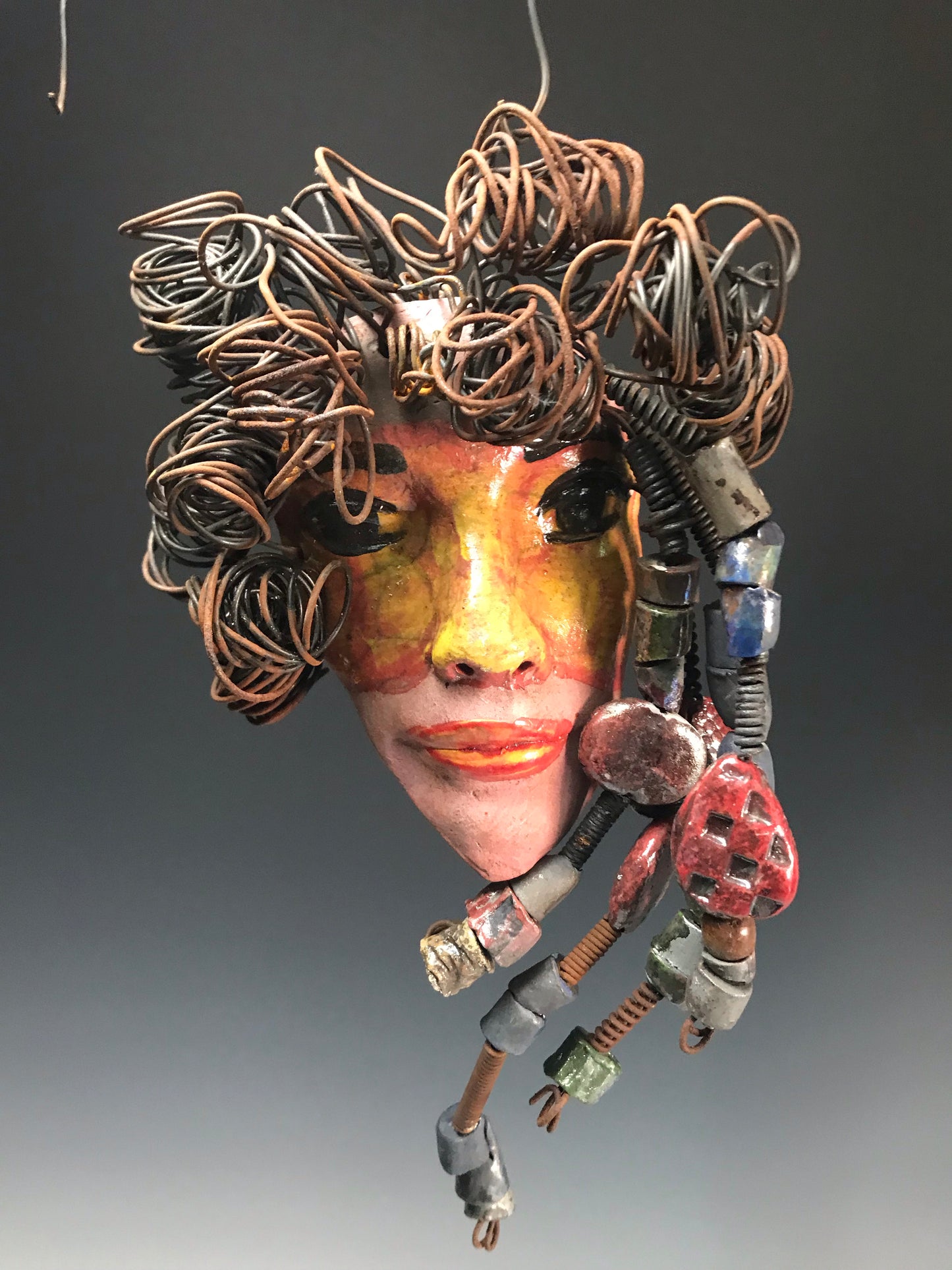 Meet Quisha! I started making mask after seeing an authentic African Mask collection at the Smithsonian Museum of African Art. I was in total awe. Quisha was inspired by my visit there. Quisha has a complexion of mustard and honey brown. She is 7" x 12" and weighs 1.3 lbs. Quisha has over 40 handmade raku fired beads. She has over 20 feet of coiled 16 gauge wire hair. Quisha won't be around long at Half Priced!