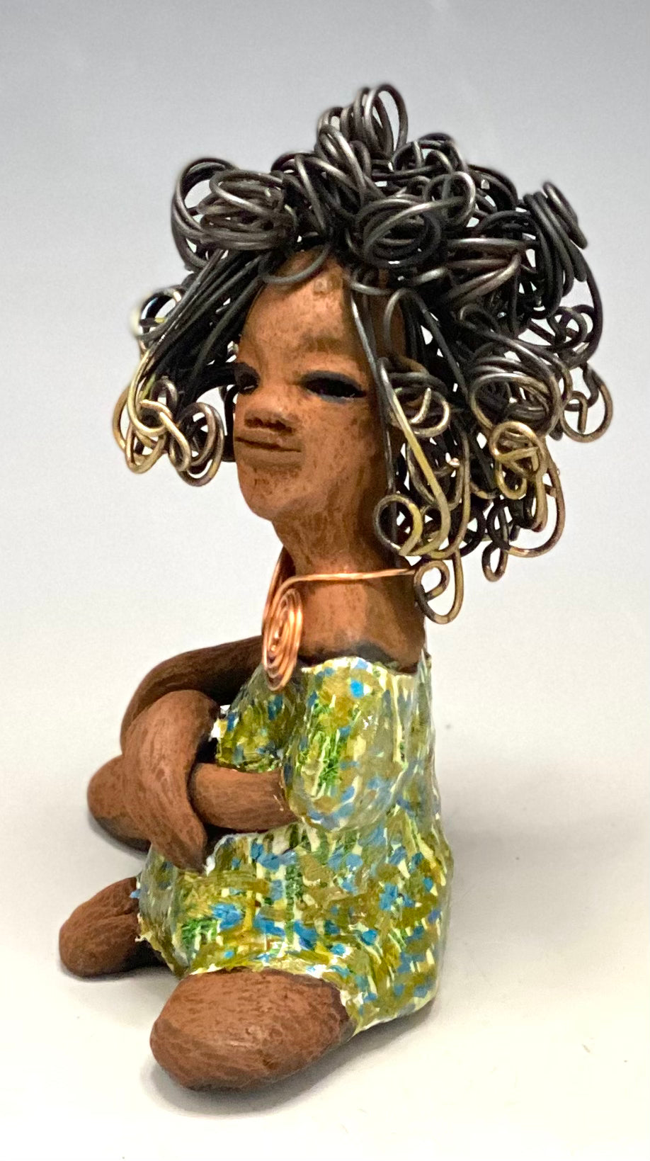 Jayla stands 7" x 5" x 4.5" and weighs 14 ozs. She has a lovely honey brown complexion with cocoa brown lips. She has a big hairstyle! Brianna has a colorful blue green antique glazed dress. She has over 15 feet of 16 gauge wire for hair. It took over 2hours just to do her hair! With eyes wide opened, Jayla has hope of finding a new home. You will love having Jayla! She will attract and spark conversation with guest in your home!