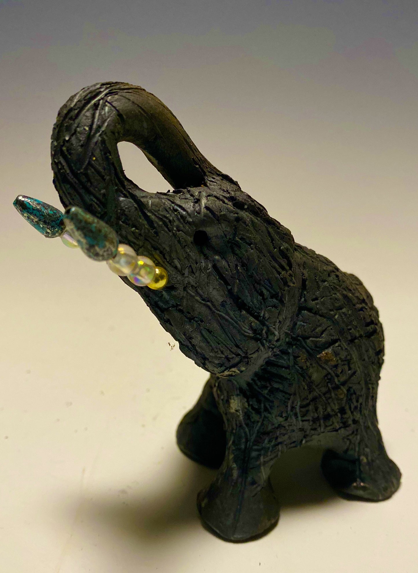 Elephants are one of my favorite animals to create. They are so majestic" Just one of these lovely Raku Fired Elephant will make an excellent gift for your BFF, or just for you . This raku fired elephant stands 7" x 2" x 2.5" and weighs 7 ounces. She has beaded tusks and a textured charcoal body. Nice!