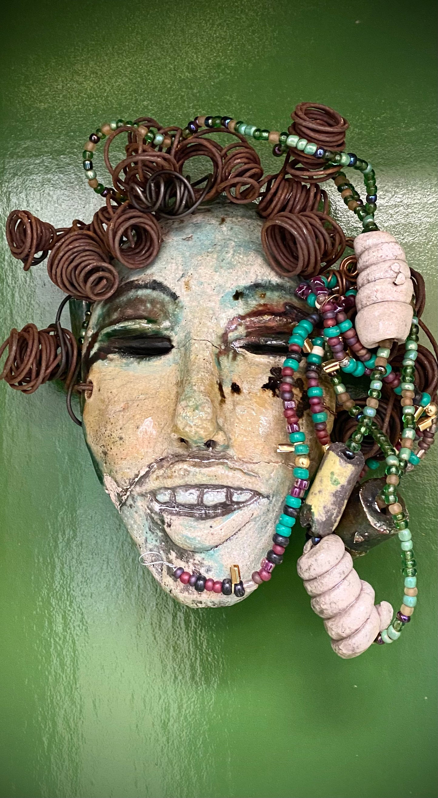 Meet Jenia! She is proud of every tooth in her mouth.... I started making art soon after seeing authentic African artwork at the Smithsonian Museum of African Art. I was in total awe. Jenia was inspired by my visit there. Jenia is 7”x 7” and weighs 1 lbs. She has a two tone copper and green complexion. Jenia has six spiral coils of hair and plenty of handmade mini beaded braids.