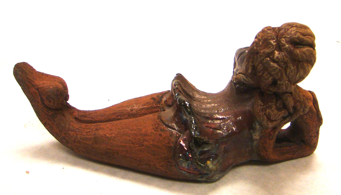Juanita stands 4" x 3" x 7" and weighs 1 lb. She has a lovely honey brown complexion. Juanita has a copper iridescent dress. Her long loving arms rest underneath her face as she caresses her brown clay hair. Juanita will definitely get your guest attention and create conversation.