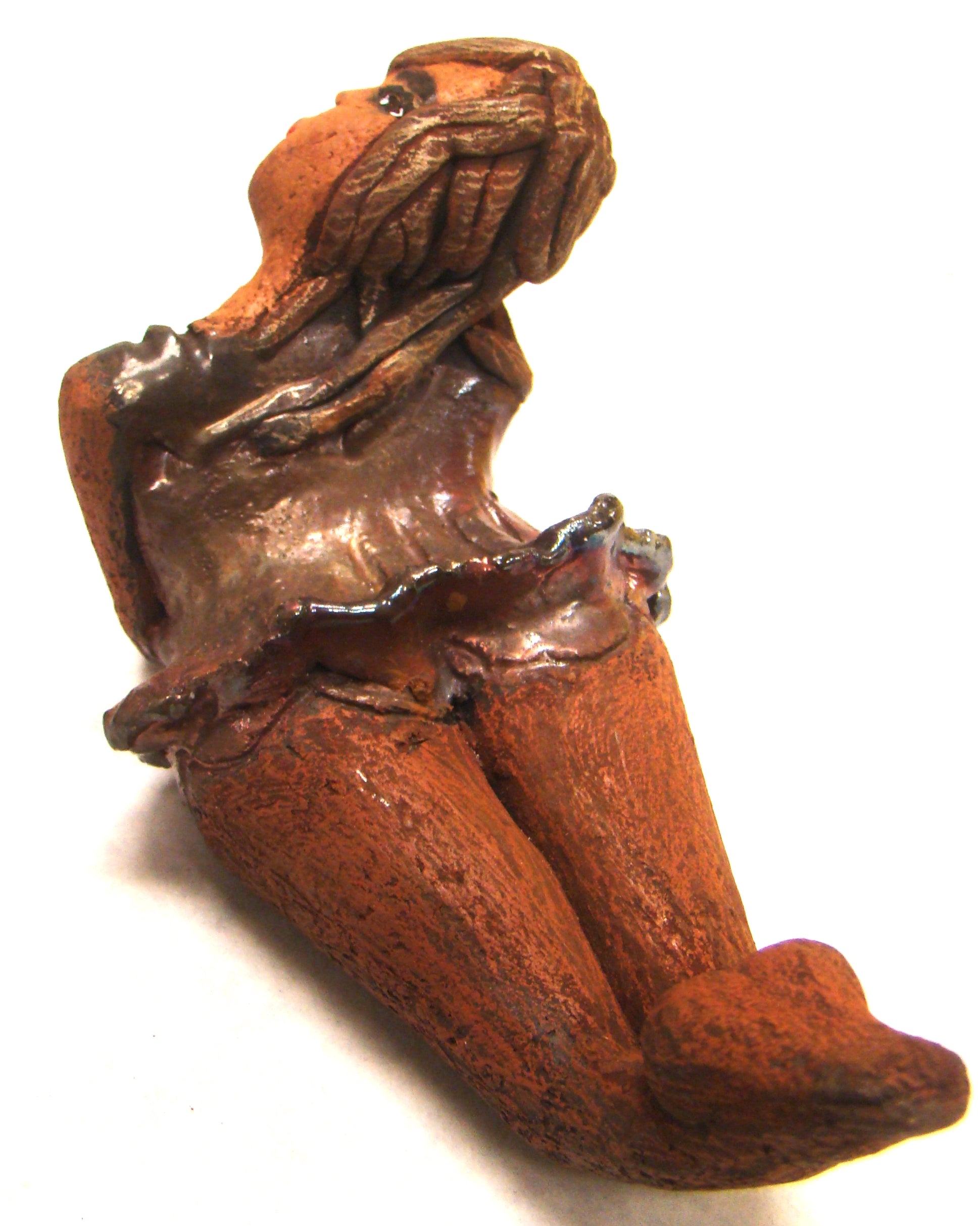 Juanita  stands 4" x 3" x 7" and weighs 1 lb.     She has a lovely honey brown complexion.     Juanita has a copper iridescent  dress.     Her long loving arms rest underneath her face as she  caresses her brown clay hair.     Juanita will definitely get your guest attention and create conversation.