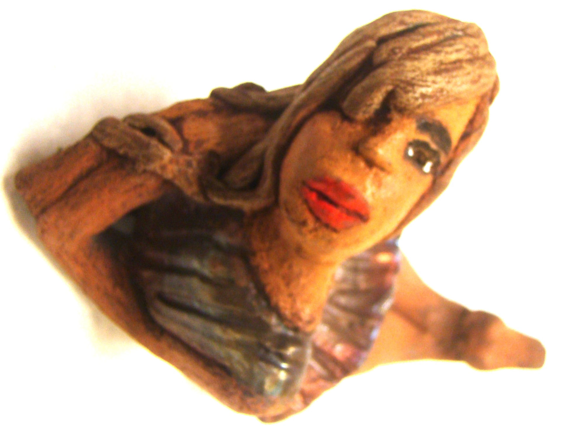 Juanita  stands 4" x 3" x 7" and weighs 1 lb.     She has a lovely honey brown complexion.     Juanita has a copper iridescent  dress.     Her long loving arms rest underneath her face as she  caresses her brown clay hair.     Juanita will definitely get your guest attention and create conversation.