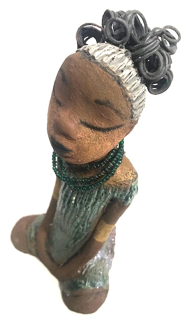 Meet Katie! Katie stands 12" x 6.5" x 5.5"and weighs 2.13 lbs. Katie has a lovely two tone honey brown complexion. She has a nice wire pony tail behind her smokey black hair. Katie has a gold band around her long loving arms. Her dress is an alligator green with streaks of copper. Katie wears an emerald beaded necklace. Katie sits patiently and waits on a new home. Free Shipping!