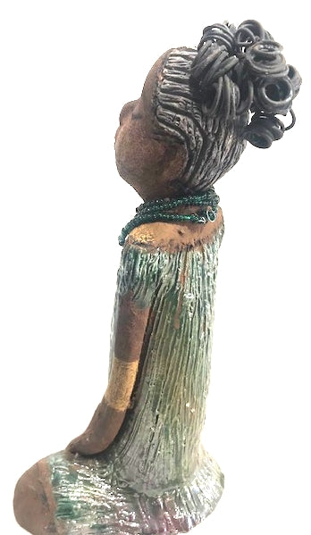Meet Katie!      Katie stands 12" x 6.5" x 5.5"and weighs 2.13 lbs.     Katie has a lovely two tone honey brown complexion.     She has a nice wire pony tail behind her smokey black hair.     Katie has a gold band around her long loving arms.     Her dress is an alligator green with streaks of copper.     Katie wears an emerald beaded necklace.  Katie sits patiently and  waits on a new home. Free Shipping!