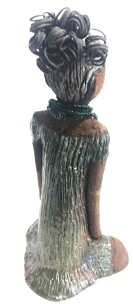 Meet Katie!      Katie stands 12" x 6.5" x 5.5"and weighs 2.13 lbs.     Katie has a lovely two tone honey brown complexion.     She has a nice wire pony tail behind her smokey black hair.     Katie has a gold band around her long loving arms.     Her dress is an alligator green with streaks of copper.     Katie wears an emerald beaded necklace.  Katie sits patiently and  waits on a new home. Free Shipping!