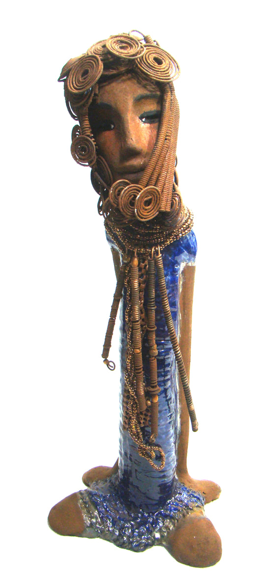 Kya stands 20" x 8" x 5" and weighs 6.04 lbs.     She has a lovely honey brown complexion.     Kya has over 40 feet of rust wire coils and spiral hair.     Her dress is a metallic blue with streaks of copper.     Her necklace is made from rust wire coils and amber beads.     Kya has long loving arms that are placed behind her.     Kya radiates like a blue diamond in the sky.     Give Kya a special place in your home!     Free Shipping!