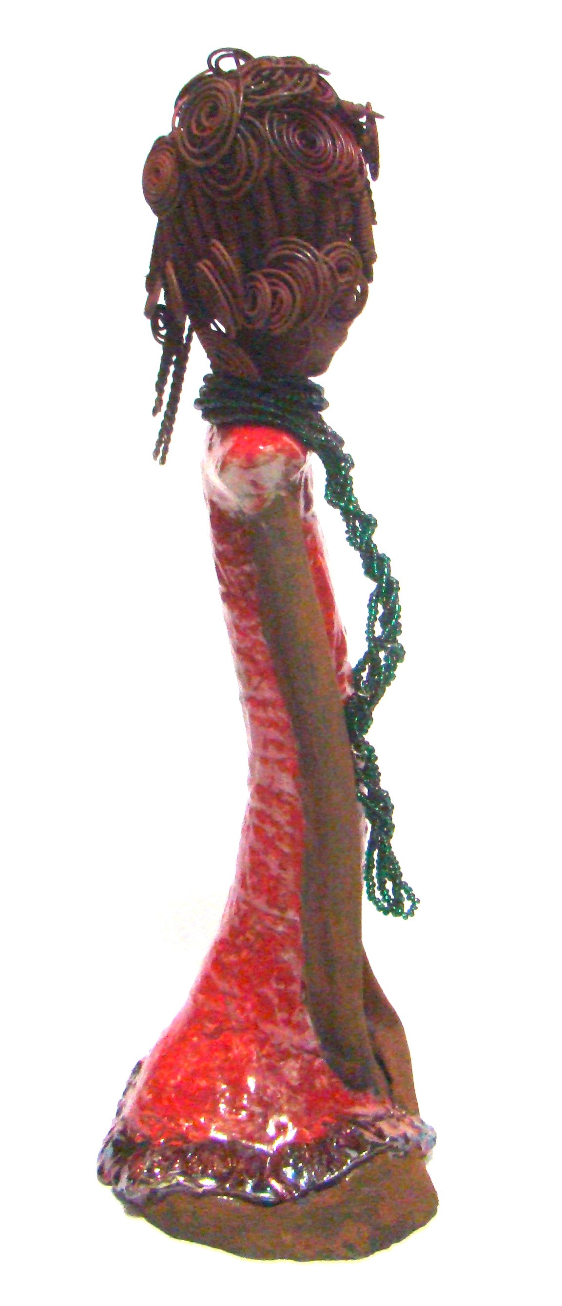Linda  profile view stands 18" x 8" x 5" and weighs 5.1lbs. She has a lovely honey brown complexion. Her hair is rust brown. It took over 3 hours and 40 feet of coiled and spiral 16 gauge wire to complete. Linda' coiled bangs slightly covers her alluring eyes. She has  apple red dress with bright copper ruffled trim. A long  string of emerald green colored beads  cascade well below her neck. Linda favorite quote “Do what you feel in your heart to be right – for you’ll be criticized anyway.”  ― Eleanor Roose
