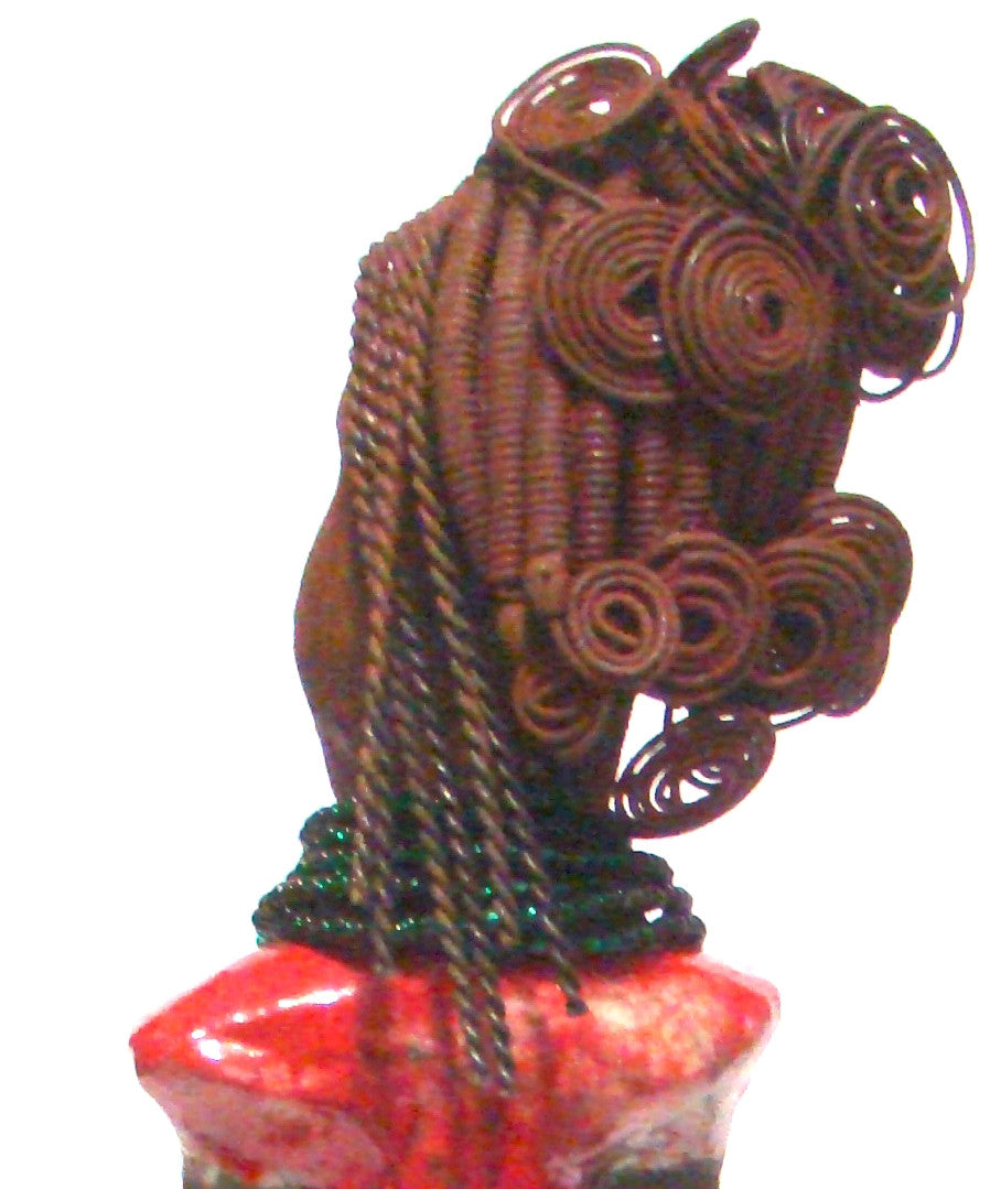 Close Up View Linda stands 18" x 8" x 5" and weighs 5.1lbs. She has a lovely honey brown complexion. Her hair is rust brown. It took over 3 hours and 40 feet of coiled and spiral 16 gauge wire to complete. Linda' coiled bangs slightly covers her alluring eyes. She has  apple red dress with bright copper ruffled trim. A long  string of emerald green colored beads  cascade well below her neck. Linda favorite quote “Do what you feel in your heart to be right – for you’ll be criticized anyway.”  ― Eleanor Roos