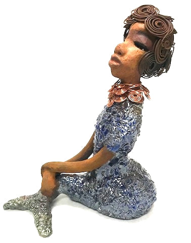 Shelia stands 12" x 10" x 4" and weighs 3.13 lbs. Shelia has a two tone honey brown complexion. She has over 15 feet of spiral wire hair which took over two hours to style. Shelia wears a textured sky blue swimsuit Her layered spiral copper necklace hangs above her long loving arm. Shelia is such a ladylike Mermaid. She sits tall and proud. Compare her to Harmony the mermaid. Give Shelia or Harmony a special place to sit in your home!