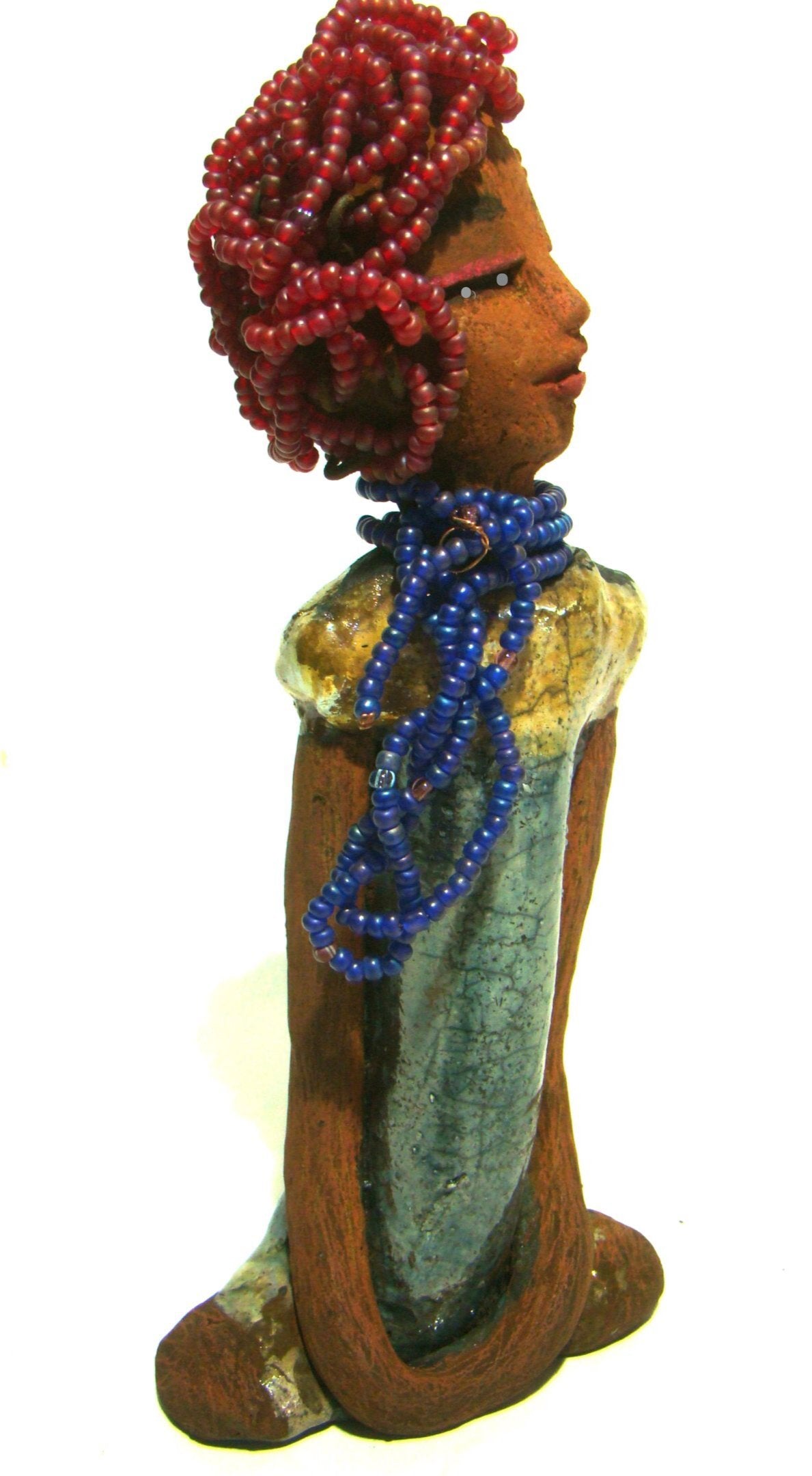 Tiffany stands 10" x 4.5" x 2" and weighs 1.05 lbs. She has a lovely honey tan complexion with purple beaded hair. Tiffany dress is glazed with blue and gold crackle. She wears a blue beaded necklace scarf.