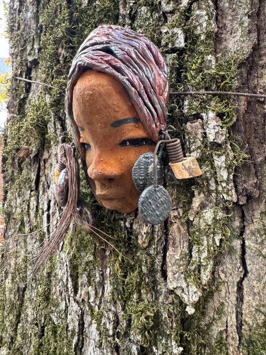 Marci boasts a beautiful honey-brown complexion, standing 5" x 7"  weighs 6.2 ozs. and embellished with coils of wire and hand-made beads. Her hair is graced with a copper glaze and was photographed outside amongst the trees. But of course, she will look fantastic no matter where you decide to place her.