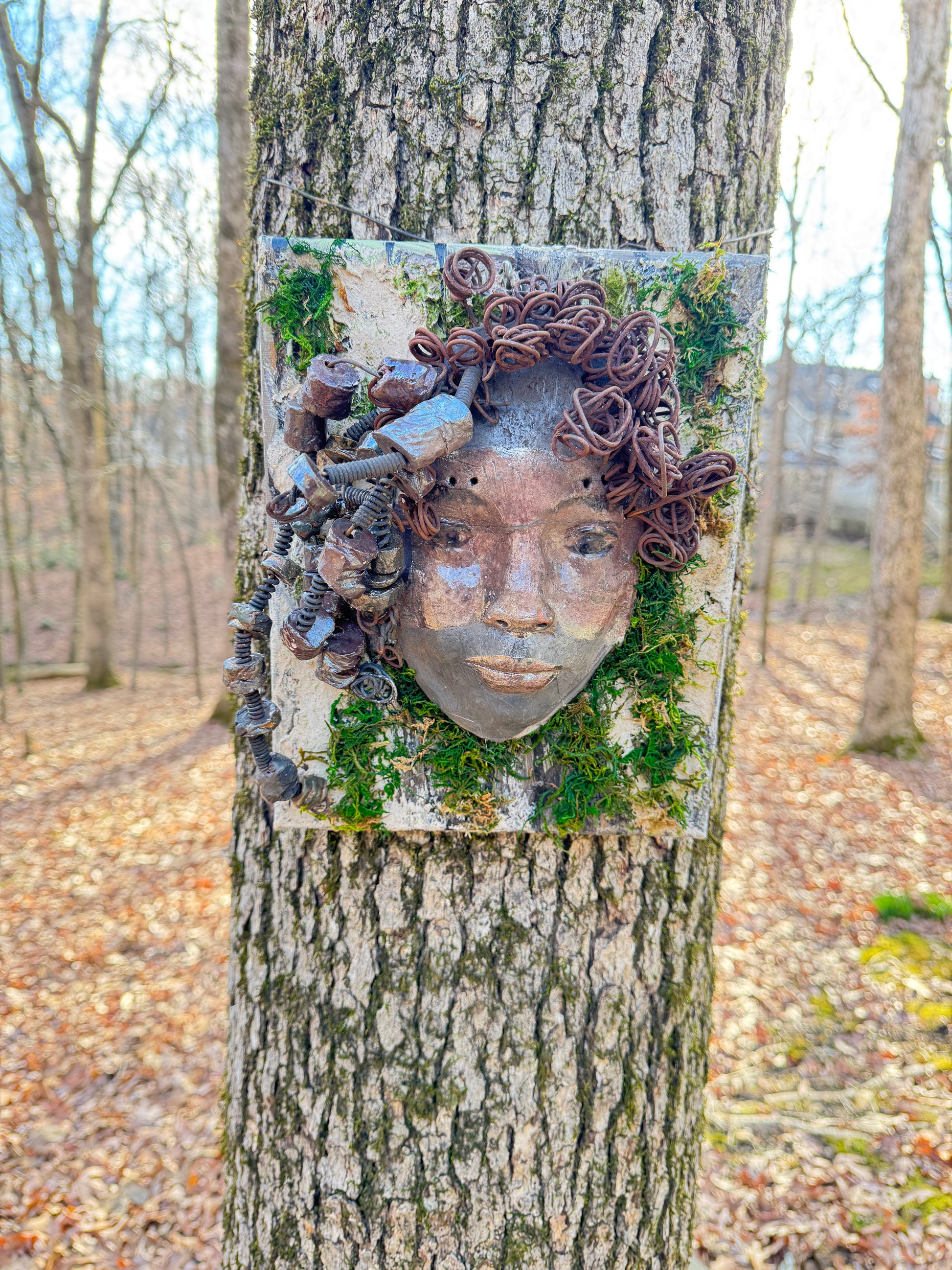 Kai is an 8 x 10 canvas mounted mixed media mask. It weighs approximately 3 pounds and features over 20 feet of 16 gauge wire and 20 handmade Raku fired beads. Her two tone complexion is highlighted by the lush tree bark emulated on the canvas.