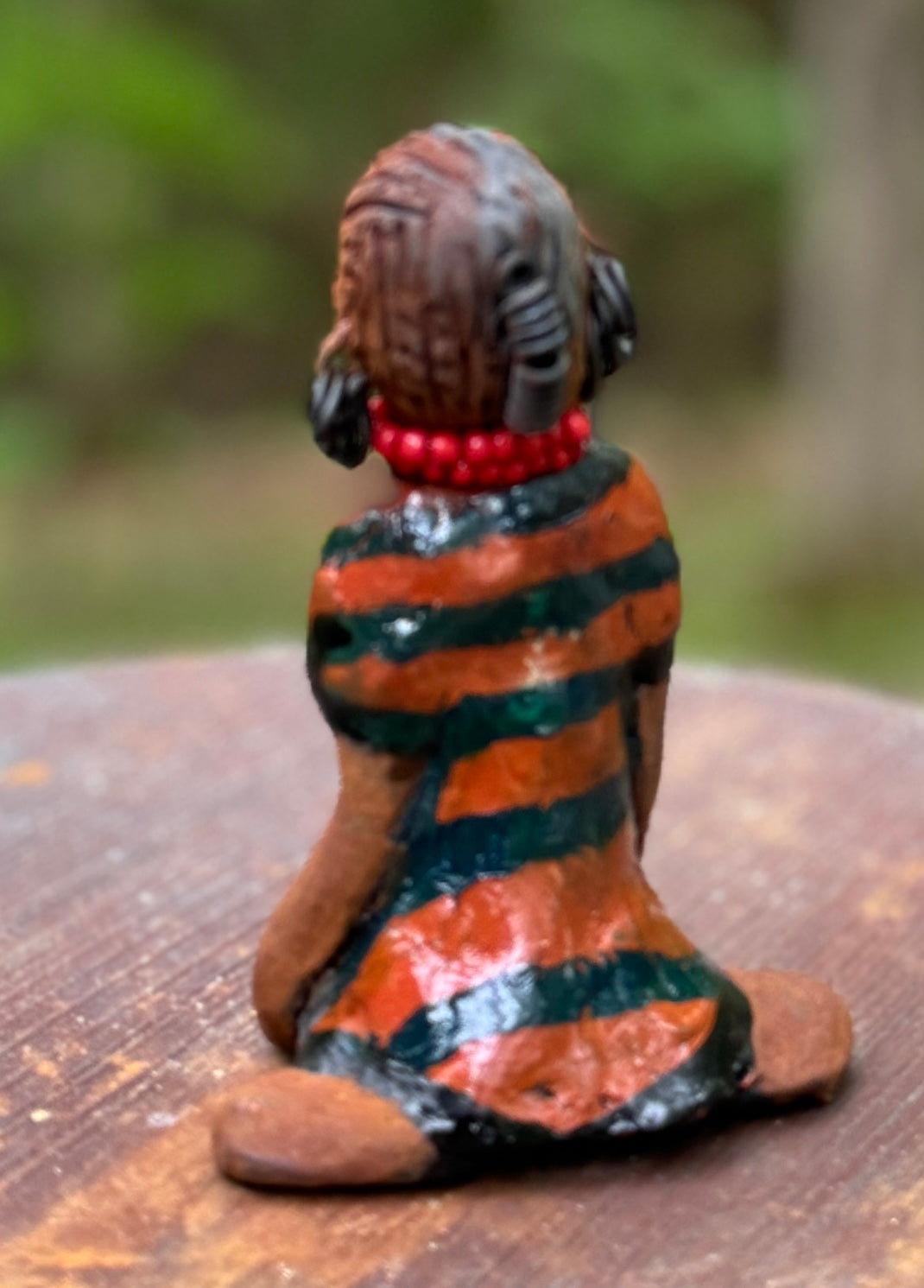 Experience the bold and fearless Shiba from the Herdew Collection! This raku fired sculpture stands tall at 5" x 3" x 3" and weighs a brave 7 ozs. Clothed in a striking orange and black dress, Shiba's coiled wire hair stretches over 1 foot. With confident outstretched arms, she strikes a yoga pose. Begin your collection with the captivating Kitty and embrace adventure!