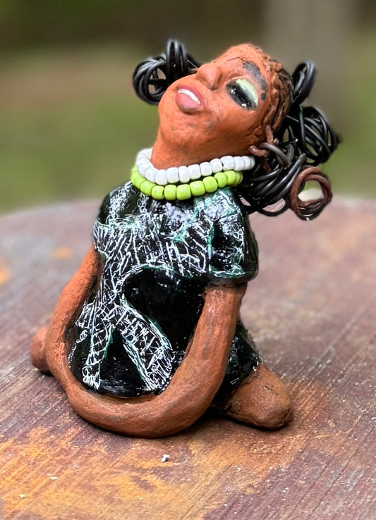 Say hello to Salana, the daring figurine standing at 4.5" x 3.5" x 3" and weighing a mere 8.5 ozs. Adorned in a striking black and white African print dress and with her coiled hair as her crown, Salana exudes boldness with her head held back and bravery as she sits in a yoga pose, radiating confidence. Embark on an adventure with the Herdew Collection and feel the exhilaration of free shipping and our customer-friendly return policy. Don't let this unique piece slip away!