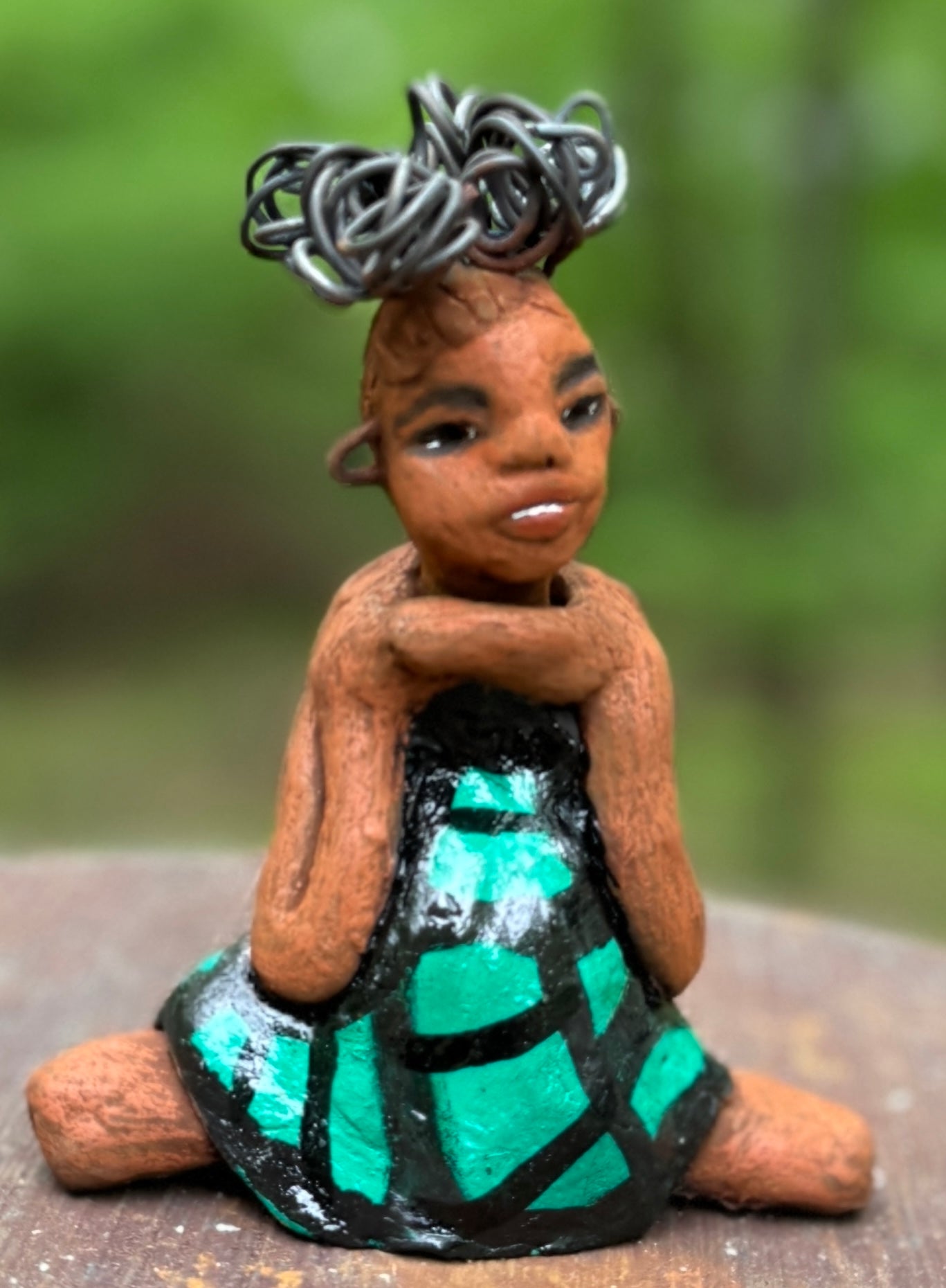 Discover Fayola, the bold figurine standing at 6" x 4” x 3” and weighing only 8.6 ozs, adorned in a striking black and green African print dress. With her hair styled in coils and her hands calmly resting in a yoga pose, Fayola emanates confidence. Join the Herdew Collection and embark on an exciting journey with our complimentary shipping and customer-friendly return policy. Don't hesitate to claim this unique treasure!