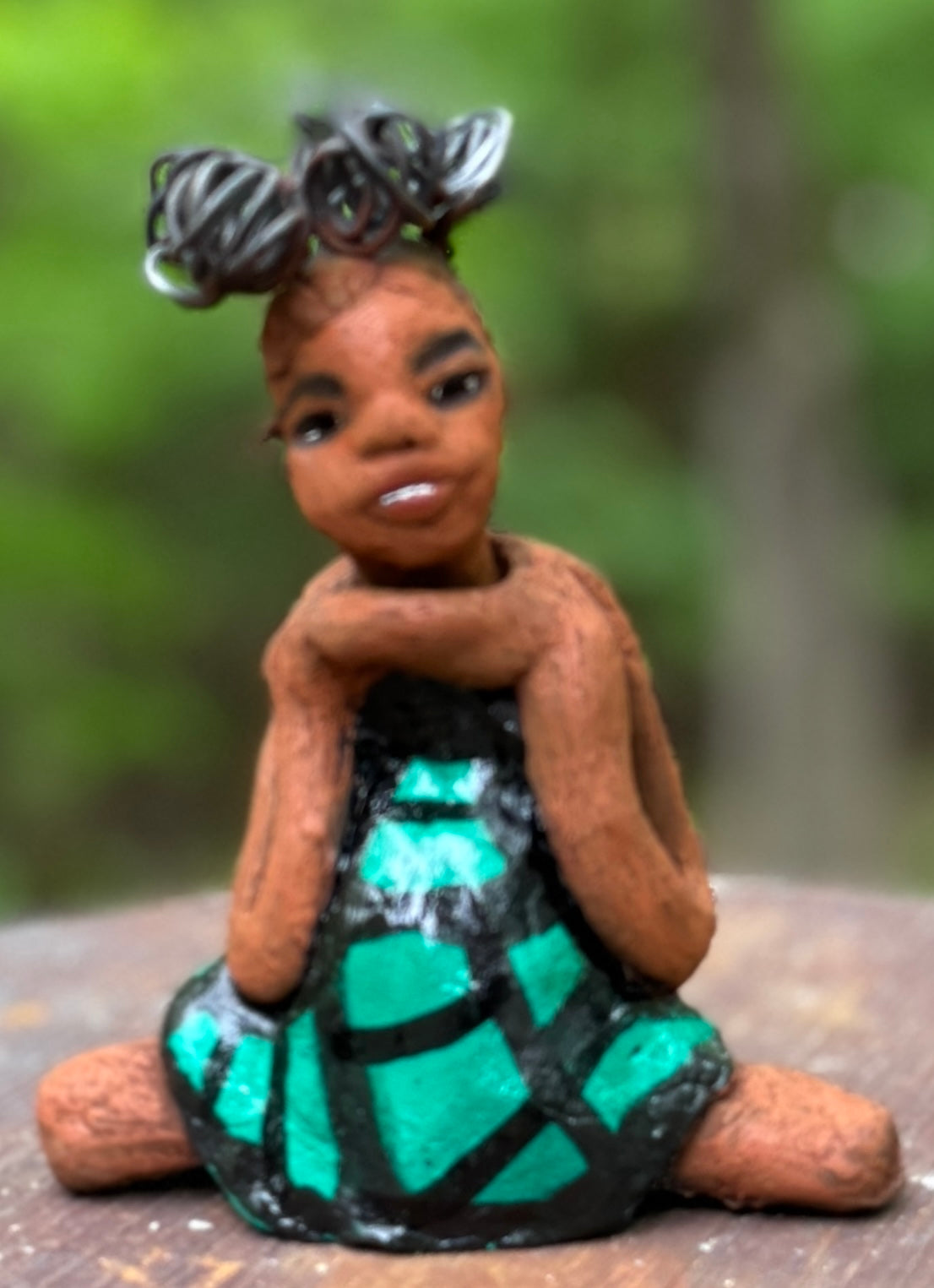 Discover Fayola, the bold figurine standing at 6" x 4” x 3” and weighing only 8.6 ozs, adorned in a striking black and green African print dress. With her hair styled in coils and her hands calmly resting in a yoga pose, Fayola emanates confidence. Join the Herdew Collection and embark on an exciting journey with our complimentary shipping and customer-friendly return policy. Don't hesitate to claim this unique treasure!