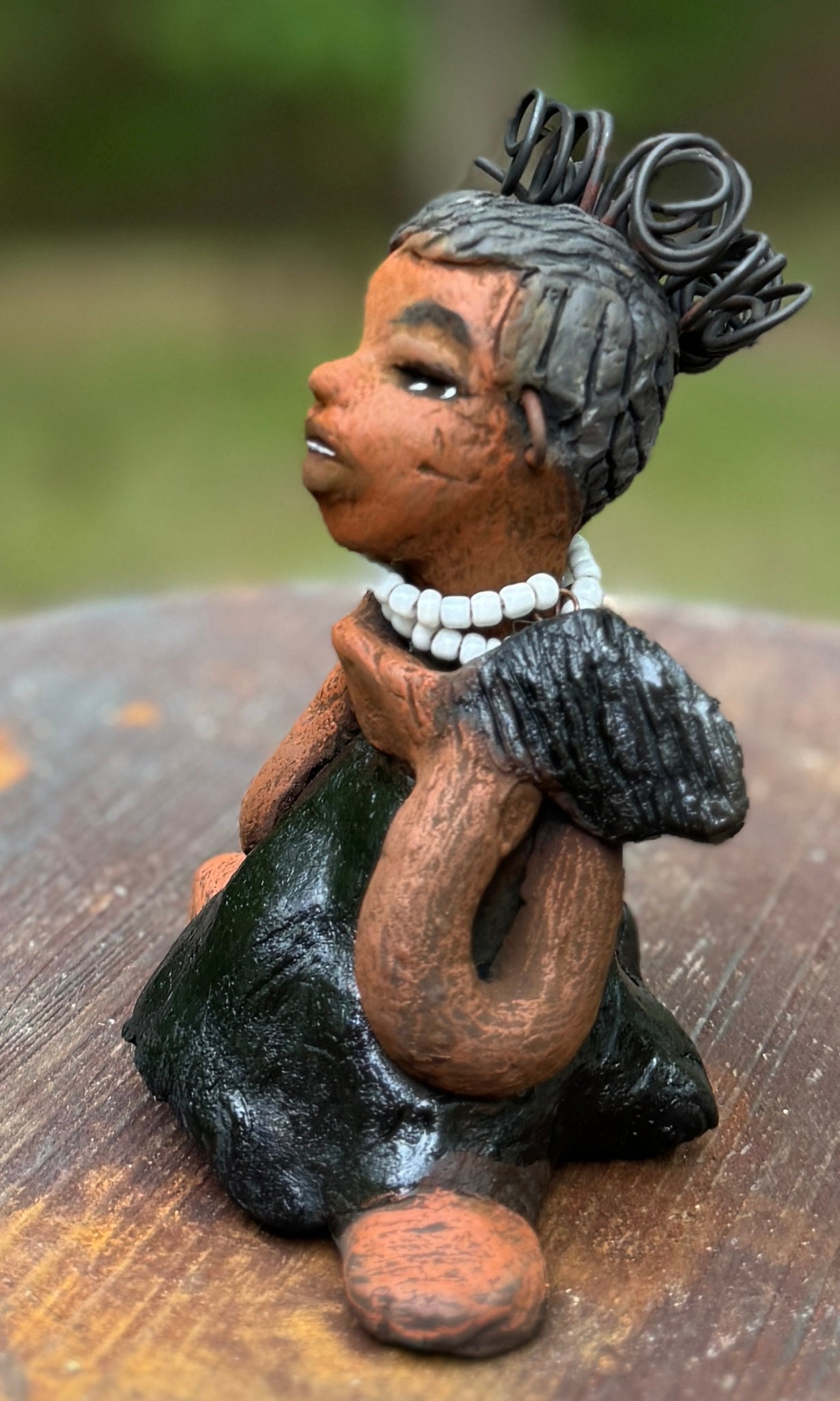 Say hello to Ama, the daring figurine standing at 5" x 4" x 3" and weighing a mere 10 ozs. Adorned in a striking black dress and with her coiled hair as her crown, Ama exudes boldness with a birth mark and bravery as she sits in a yoga pose, radiating curiosity. Embark on an adventure with the Herdew Collection and feel the exhilaration of free shipping and our customer-friendly return policy. Don't let this unique piece slip away!