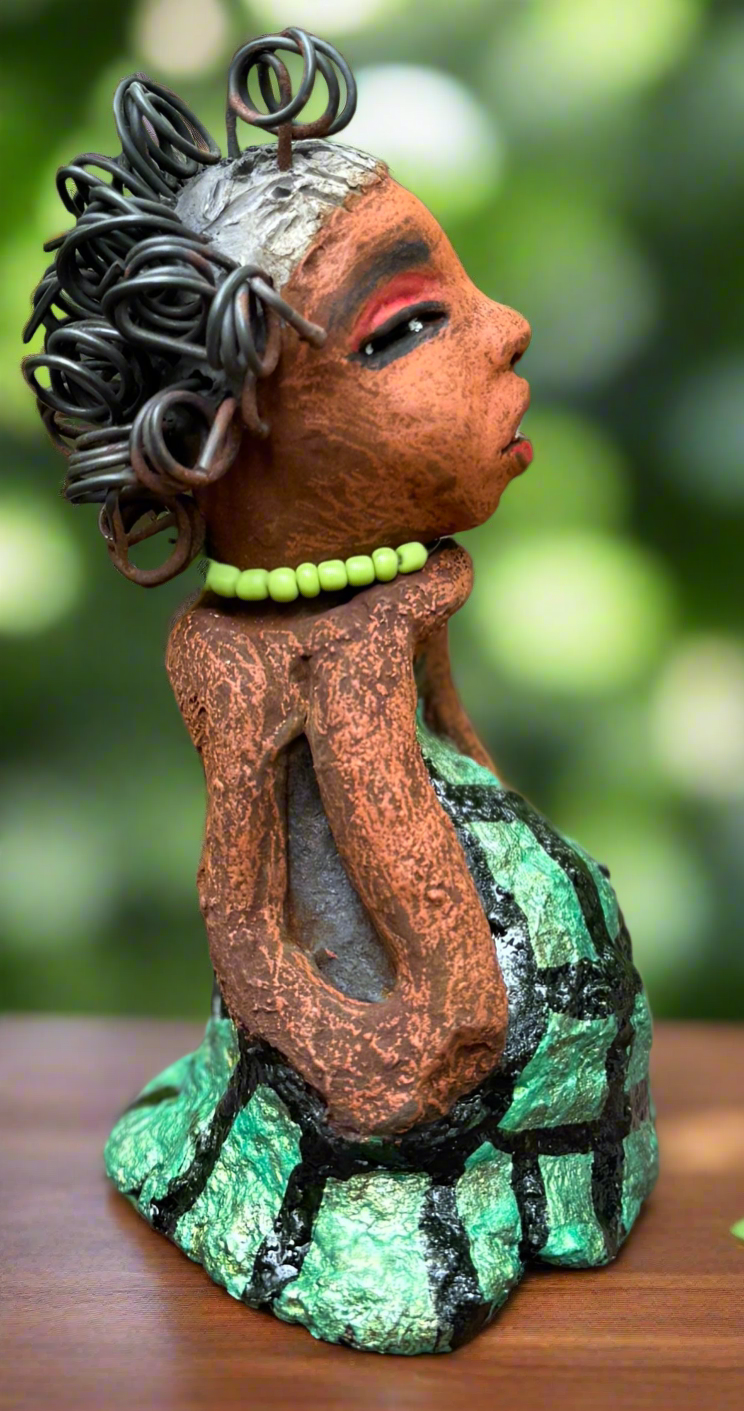 Introducing Mira, the fearless figurine measuring 6.5" x 3.5" x 3" and weighing only 13.5 ozs. Clad in a stunning black and green African print dress, with her coiled hair as her crown, Mira exudes audacity as she confidently rests her hands underneath her head in a yoga pose. Join the Herdew Collection and embark on a journey of excitement with our free shipping and customer-friendly return policy. Don't miss out on this one-of-a-kind treasure!



