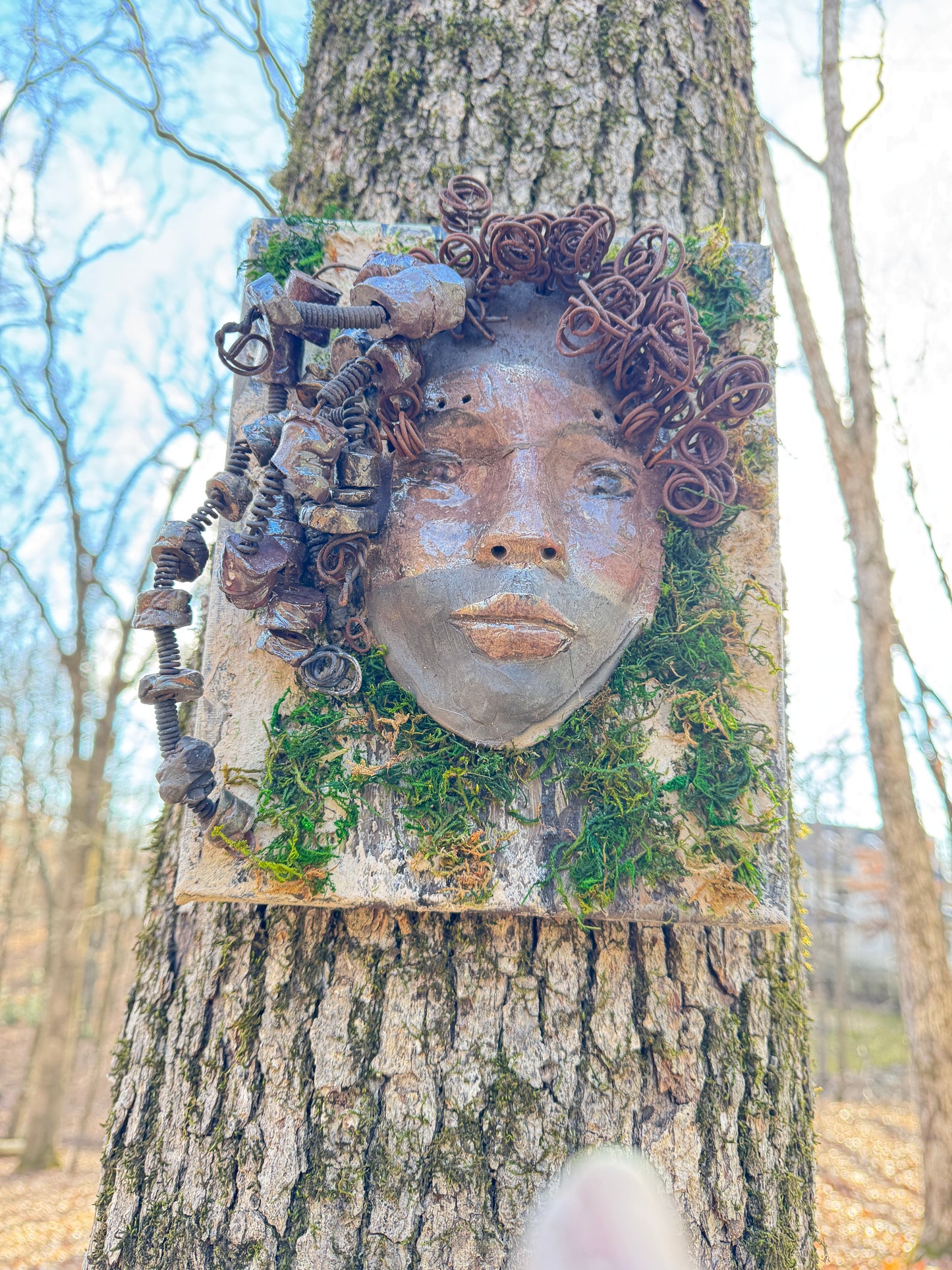 Kai is an 8 x 10 canvas mounted mixed media mask. It weighs approximately 3 pounds and features over 20 feet of 16 gauge wire and 20 handmade Raku fired beads. Her two tone complexion is highlighted by the lush tree bark emulated on the canvas.