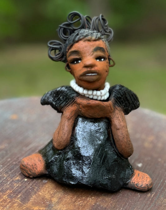Say hello to Ama, the daring figurine standing at 5" x 4" x 3" and weighing a mere 10 ozs. Adorned in a striking black dress and with her coiled hair as her crown, Ama exudes boldness with a birth mark and bravery as she sits in a yoga pose, radiating curiosity. Embark on an adventure with the Herdew Collection and feel the exhilaration of free shipping and our customer-friendly return policy. Don't let this unique piece slip away!