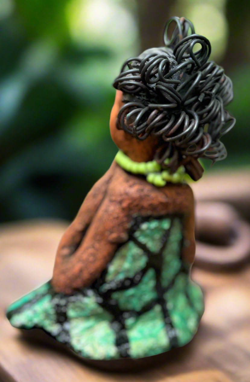 Introducing Mira, the fearless figurine measuring 6.5" x 3.5" x 3" and weighing only 13.5 ozs. Clad in a stunning black and green African print dress, with her coiled hair as her crown, Mira exudes audacity as she confidently rests her hands underneath her head in a yoga pose. Join the Herdew Collection and embark on a journey of excitement with our free shipping and customer-friendly return policy. Don't miss out on this one-of-a-kind treasure!


