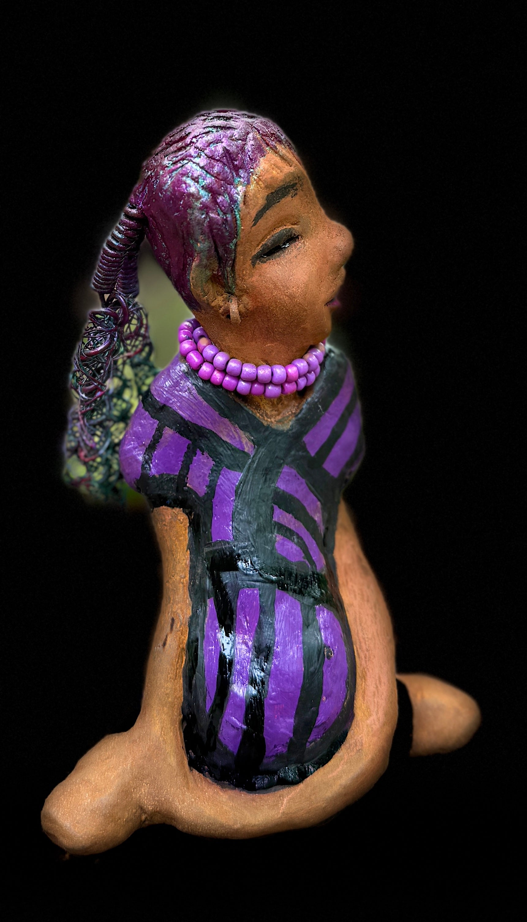 Zola is 7" x 5" x 3" raku fired scupture and weighs 12 ozs.<br>She wears a lustrous striped purple dress.<br>Her coiled wire hair is her crown of glory.<br><br>Zola sits in a yoga pose. Her expression is &nbsp;of curiosity. She will make an ideal beginning piece from the Herdew Collection!<br>Free Shipping