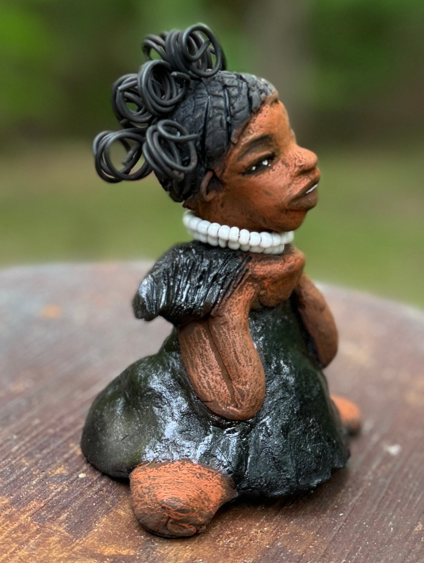 Say hello to Ama, the daring figurine standing at 5" x 4" x 3" and weighing a mere 10 ozs. Adorned in a striking black dress and with her coiled hair as her crown, Ama exudes boldness with a birth mark and bravery as she sits in a yoga pose, radiating curiosity. Embark on an adventure with the Herdew Collection and feel the exhilaration of free shipping and our customer-friendly return policy. Don't let this unique piece slip away!