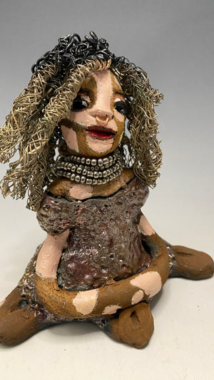 Anita stands 6.5" x 6" x 3" and weighs 1.3 lbs., with vitiligo. She loves the skin she's in! Her lips are painted with a warm ruby red, and long twisted white and gold wire locs that extend to her waist give her a unique style. Her dress is finished with a copper-antique glaze and over 75 feet of 16 and 24 gauge wire. Her bright eyes evoke a sense of hope. Add Anita to your family and she'll sure to be a conversation starter. Have questions? Ask away!