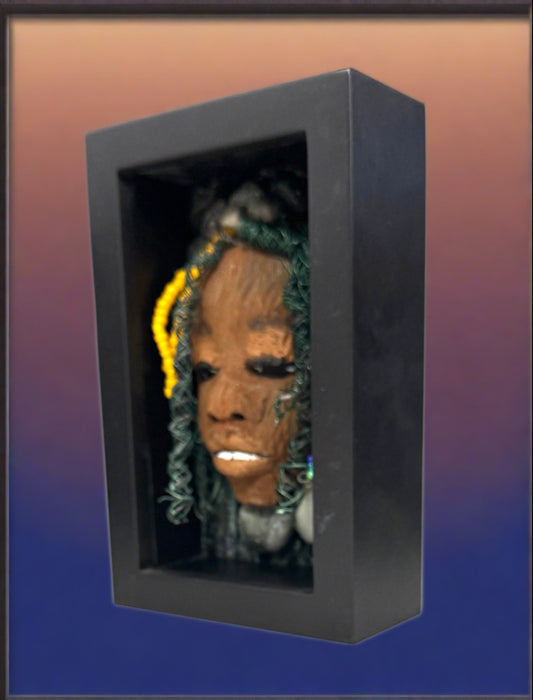 Jessie is a "4 x 6" raku mask displayed in a glass covered black shadowbox, accented with a beautiful two-tone honey brown complexion. Her intricate hair, made of 16 and 24 gauge wire, measures over 50 feet in length. With a contagious smile, Jessie adds a touch of elegance to any home decor.