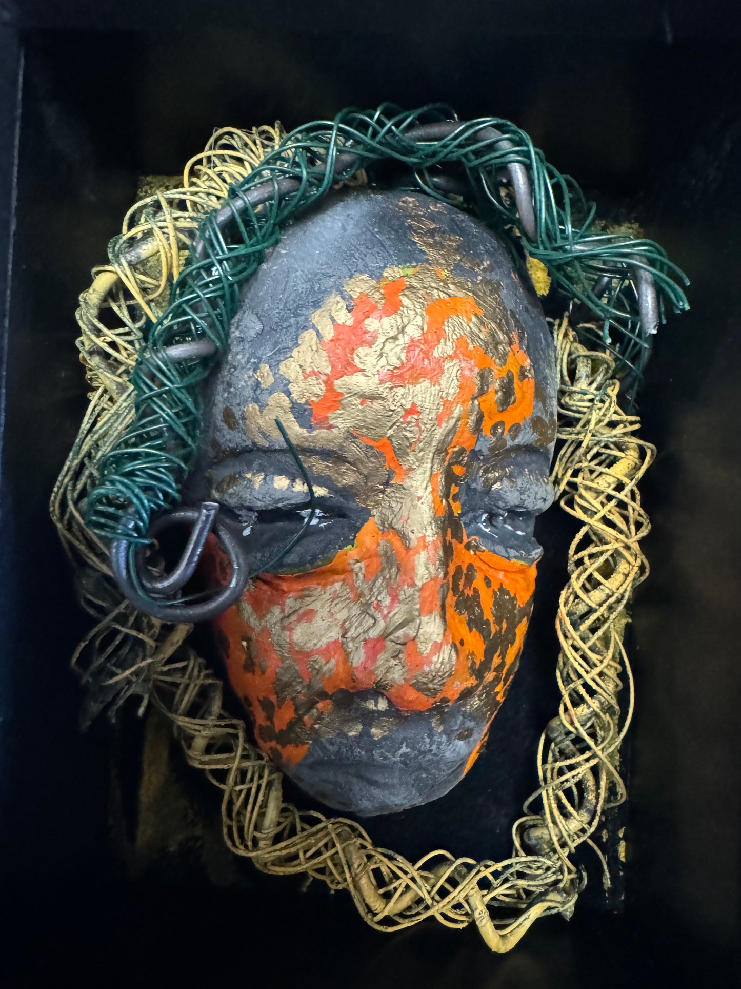 Jake is a mixed media mask that is raku fired and enclosed in a 4“ x 4“ black shadowbox. He has over 25 feet of 16 and 24 gauge wire as hair. 