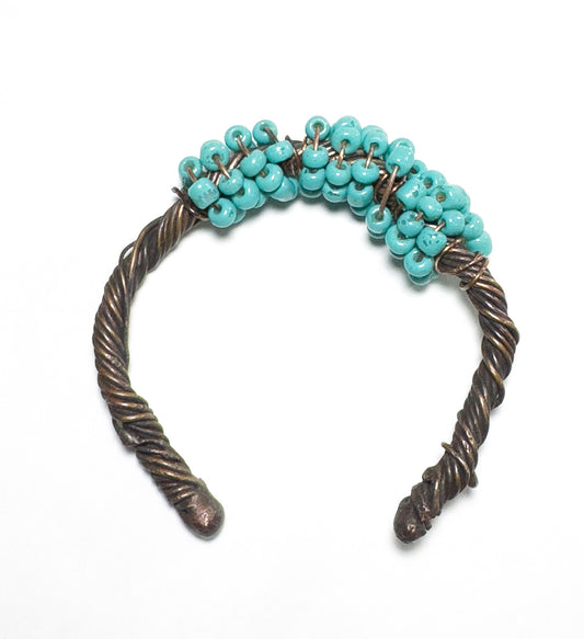 This adjustable copper bracelet features a baby blue beads on a twisted copper band. It is sure to provide an elegant touch to any outfit.