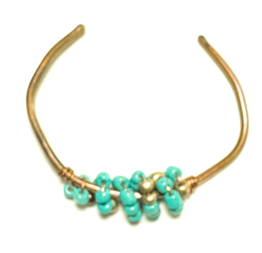 This adjustable copper bracelet features a baby blue beads on a copper band. It is sure to provide an elegant touch to any outfit.
