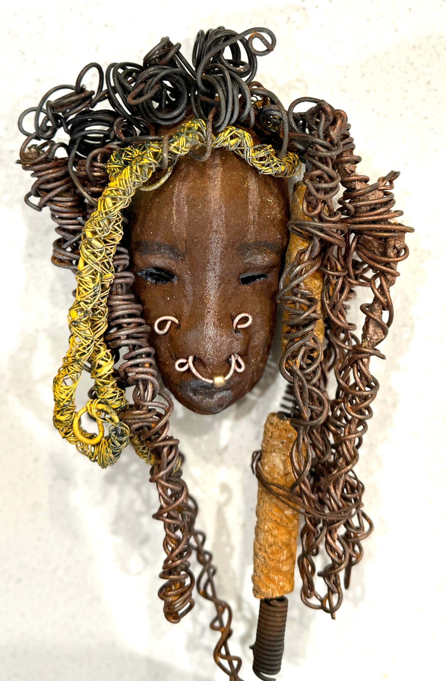 At 5" x 8" in size, Ike makes a stunning addition to walls, trees, and shadow boxes. His signature brown and amber braided hair is ornamented with handcrafted Raku beads, while his skin has a warm honey brown hue. Each piece is equipped with over 20 feet of top-notch 16 & 24-gauge wire in the hair. This fashionable sculpture will bring a modern flair to any room - simply place it in a shadow box and enjoy!