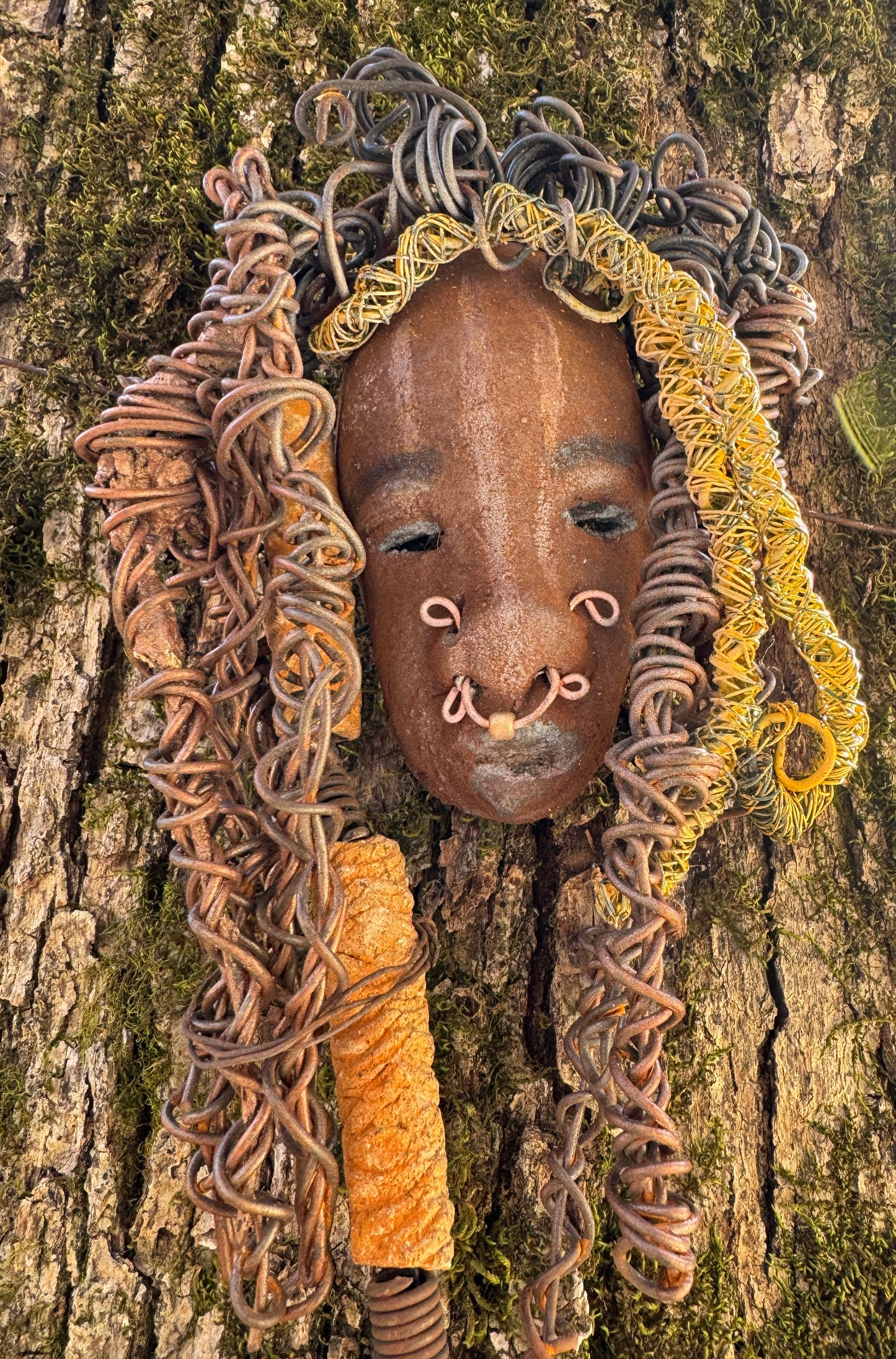 At 5" x 8" in size, Ike makes a stunning addition to walls, trees, and shadow boxes. His signature brown and amber braided hair is ornamented with handcrafted Raku beads, while his skin has a warm honey brown hue. Each piece is equipped with over 20 feet of top-notch 16 & 24-gauge wire in the hair. This fashionable sculpture will bring a modern flair to any room - simply place it in a shadow box and enjoy!