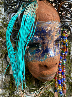 G.G features a two-tone copper-brown textured complexion with discernible red-brown lips. Boasting dimensions of 5"x5" and a weight of 6 oz., G.G includes beads and over 10 feet of 24- and 16-gauge coiled wire hair. Position G.G in a special area and keep secure.