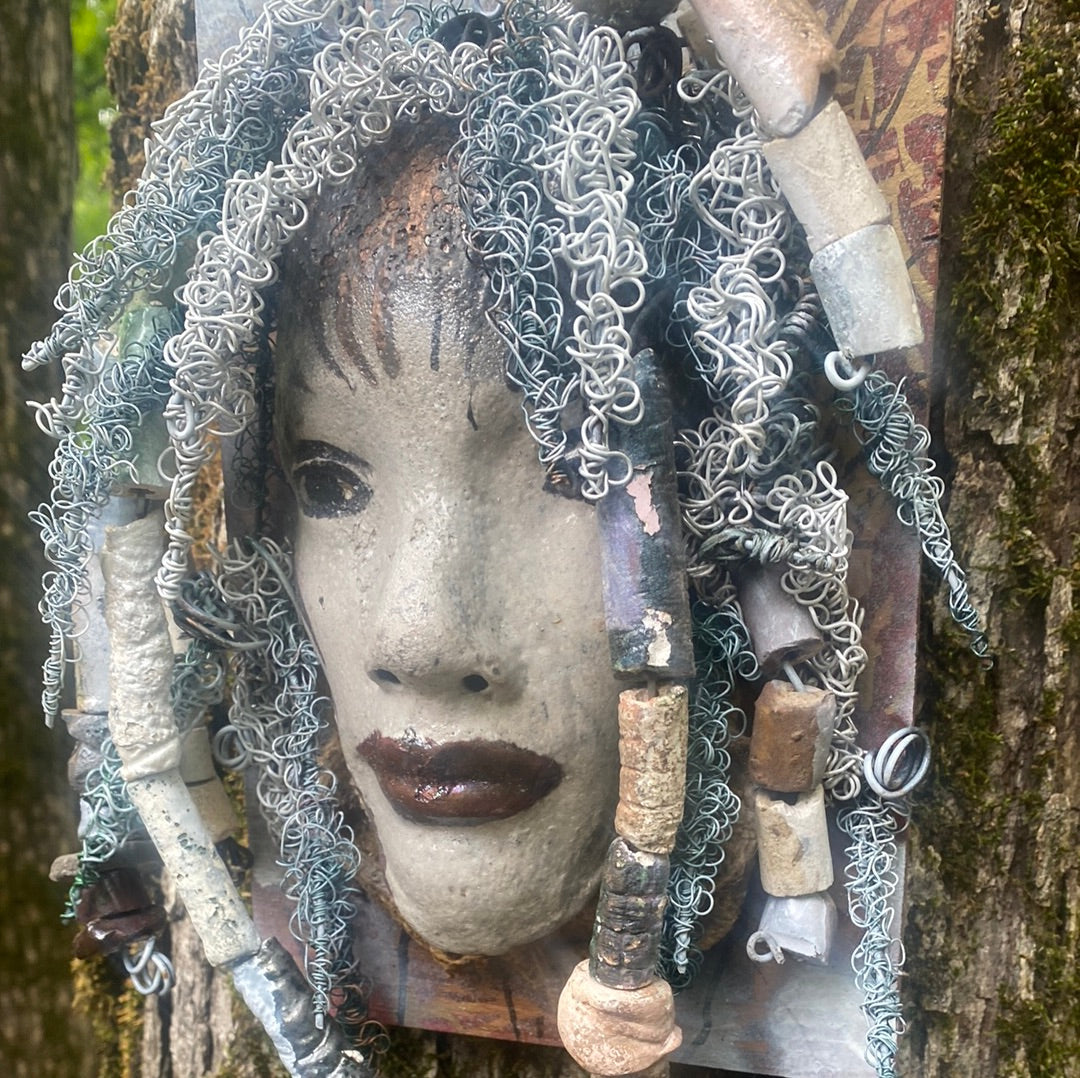 Summer has a white complexion and ruby red lips! She is 6”x 8”" and weighs 2.1 lbs. Summer has over 30 handmade raku fired beads. She has over 80 feet of coiled 16 and 24 gauge wire hair.