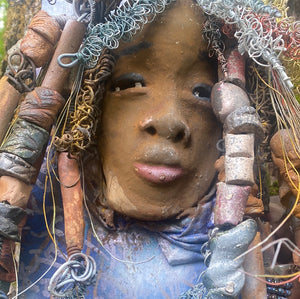 Valarie is mounted  5” x 8 x 1 and weighs 1.13 lbs.   She has a contagious smile. Valarie face has a lovely honey brown complexion. She has over 20 handmade raku fired beads  Over 60 feet of 16 and 24 gauge twisted wire for hair!
