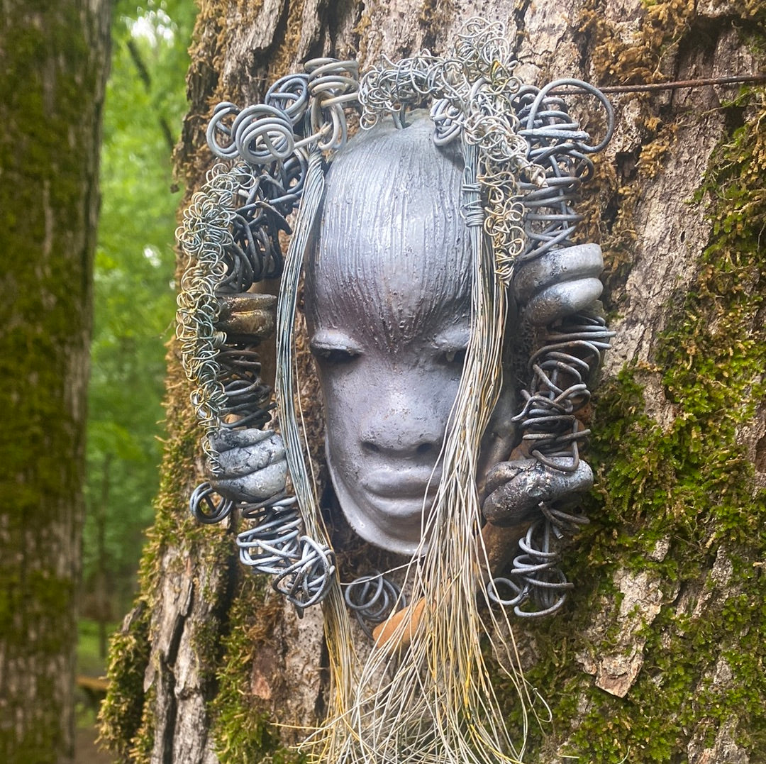 Zaya has a metallic  white complexion. She is 7" x 8" and weighs  11 ozs. Zaya has over 15 handmade raku fired beads. Zaya has over 25 feet of  copper coiled 16 gauge wire hair