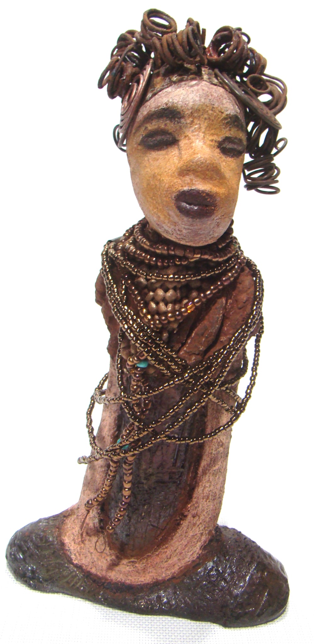 Cardi stands 11" x 5.5" x 3" and weighs 1.14 lbs. She has an awesome two tone honey beige complexion. Cardi wears a dark metallic copper dress with a chocolate ruffle scarf.  She wears a multitude of amber colored hand strung beads. I do believe Cardi would like it if you gave her a space in your home!