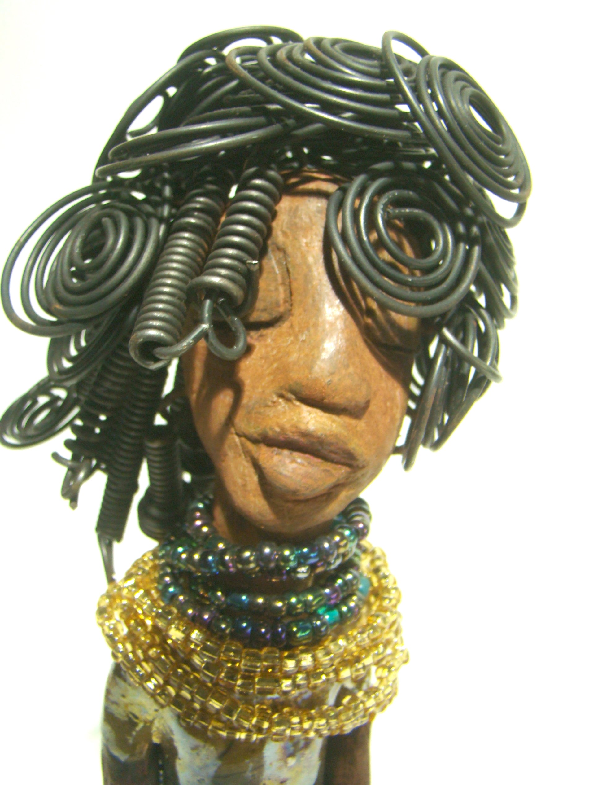 Sophia stands 10.5" x 4" x 3" and weighs 1.10 lbs. She has a  honey brown complexion with curls, coils and twisted, wire hair. Sophia wears a light blue crackle dress with a dazzling gold and multicolored beaded necklace.