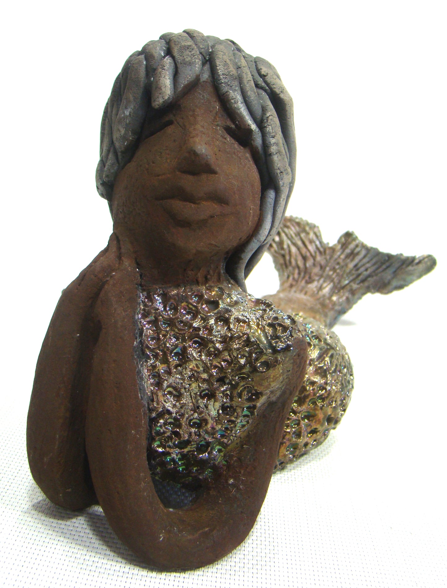 Meet Belinda!      Belinda is a voluptuous mermaid.     She stands 6.5" X 5" 9.5" and weighs 2.04 lbs.     Belinda has a dark chocolate complexion.     She wears a  dark smokey clay hairstyle.     She wears a glossy metallic swimsuit.     Belinda has a wide tail.     She will  definitely get somebody's attention.