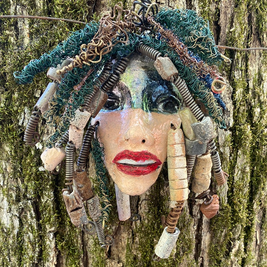 Lena has a two tone copper gold complexion. She is 9" x 9" and weighs  1 lbs. Lena has over 25 handmade raku fired beads. Lena has over 100 feet of coiled 24 and 16 gauge wire hair.